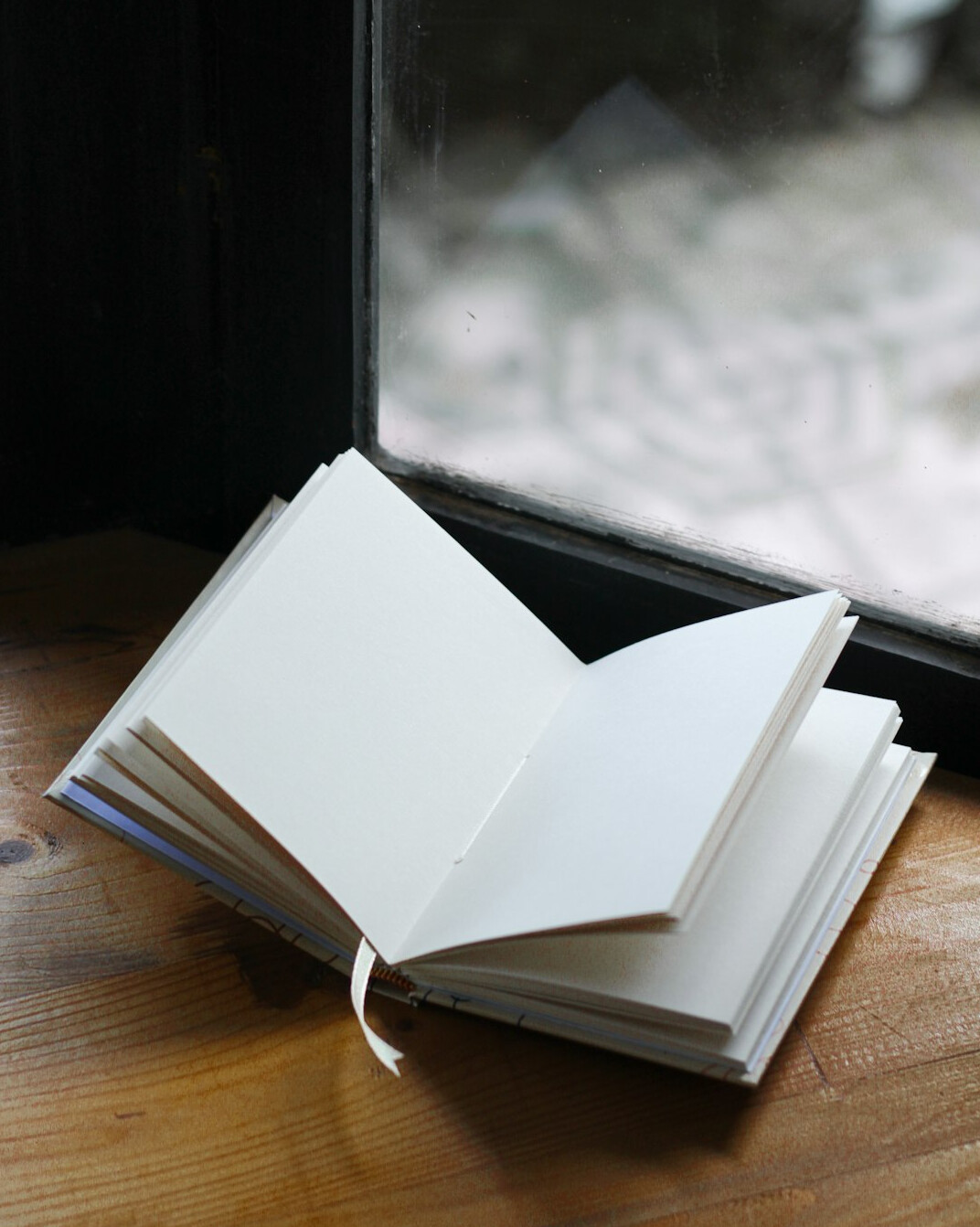 Detective notebook with pen and magnifying glass on a wooden desk